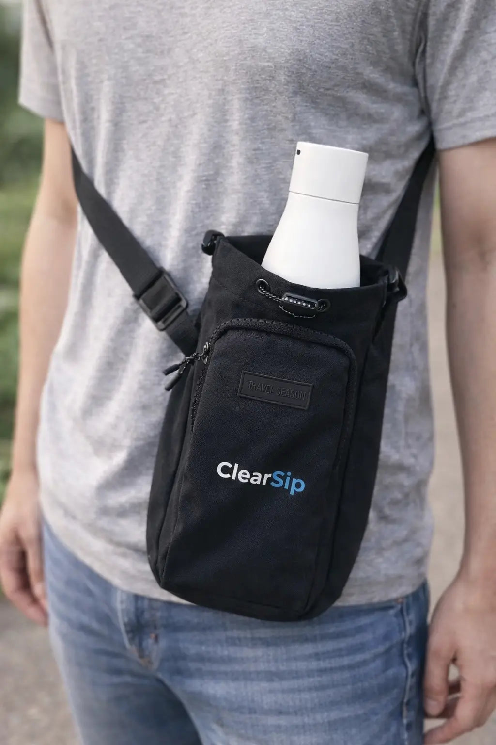 Man draagt zwart ClearSip waterfles tasje crossbody met witte slimme water fles erin – ideaal voor onderweg, wandelen of festivals